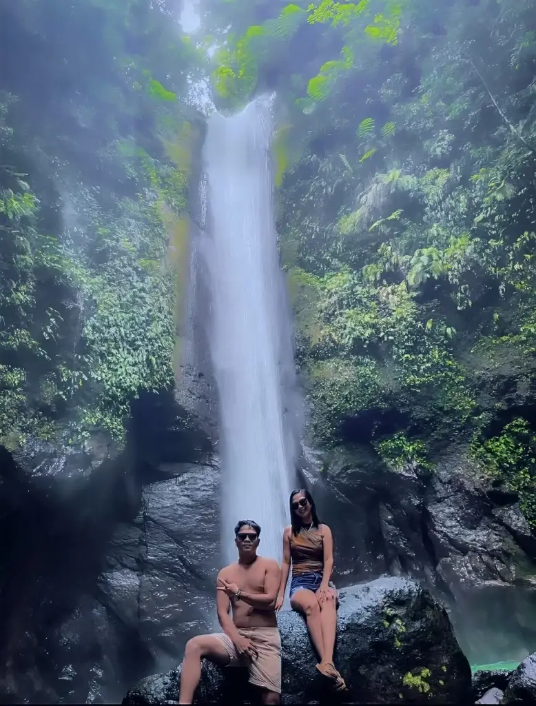 A picture of a couple near the  falls. 