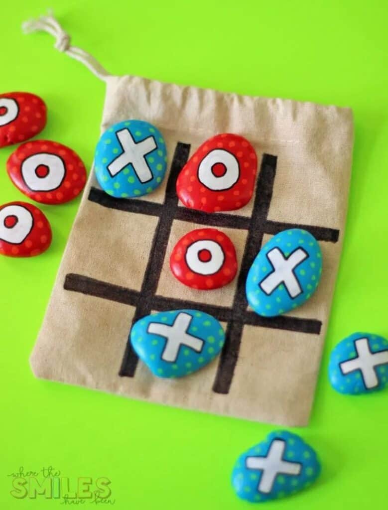 painted rock tic tac toe on green background