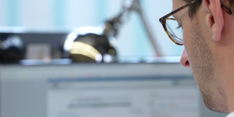 Corporate brand film production shot of a business professional sitting at a modern desk reviewing video marketing services.