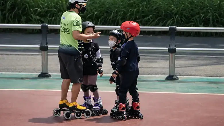 공원이나 야외 광장에서 인라인 강습을 받는 아이들