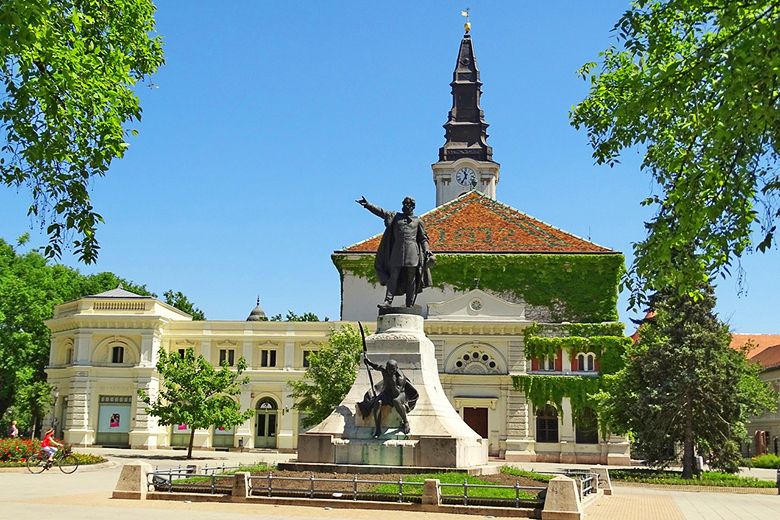 Kossuth Lajos szobra a kecskeméti Kossuth téren, háttérben a Törvényszék épületével.