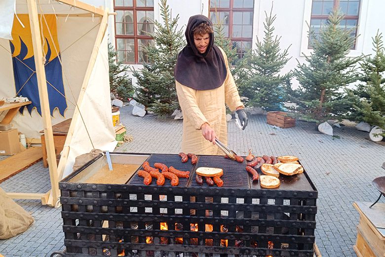 A pozsonyi vár udvarán tartott középkori vásáron lángolt kolbászokat sütnek 2025-ben