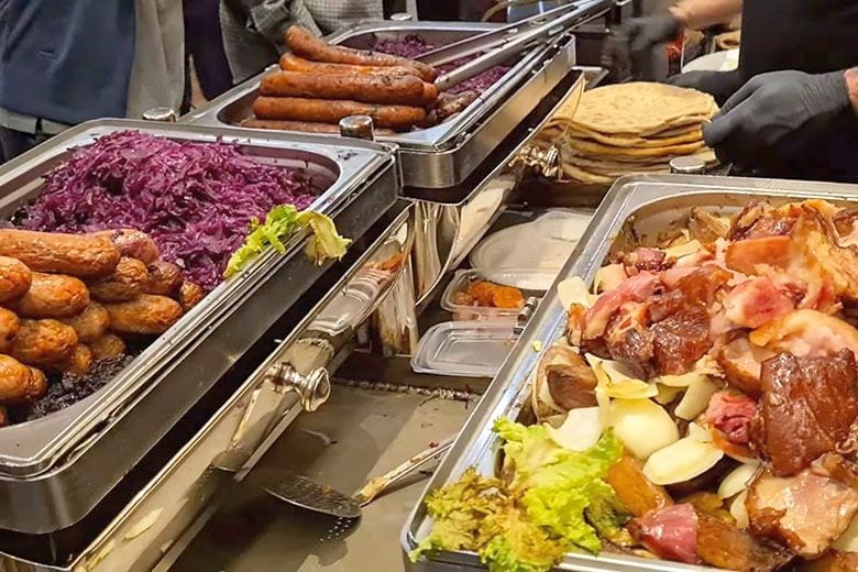 Meleg étel kínálóedények sült ételekkel az Indoor téli sörfesztiválon Budapesten.