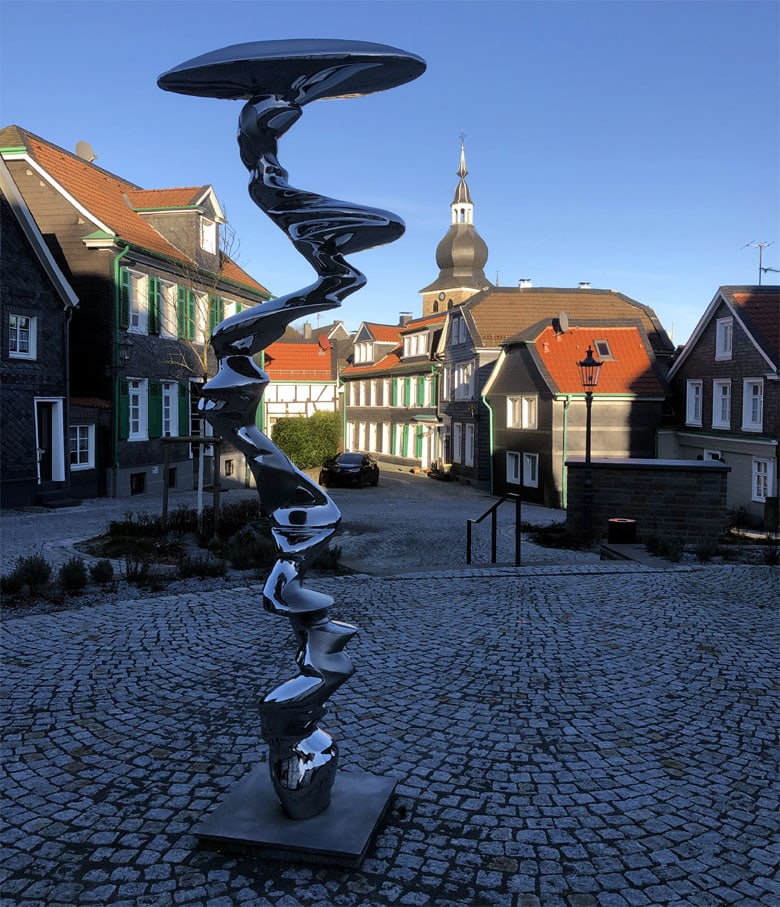 Fotografie Lennep Munsterplatz Richtung Stadtkirche. Die Fotografie zeigt die Skulptur "Der Pfad" im Vordergrund. Fotografiert am 11.01.2024 sonnig, klarer blauer Himmel