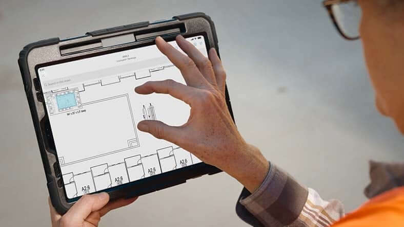 Inginer analizand o plansa complexa de constructii in aplicatia AutoCAD pe tableta direct in locatie
