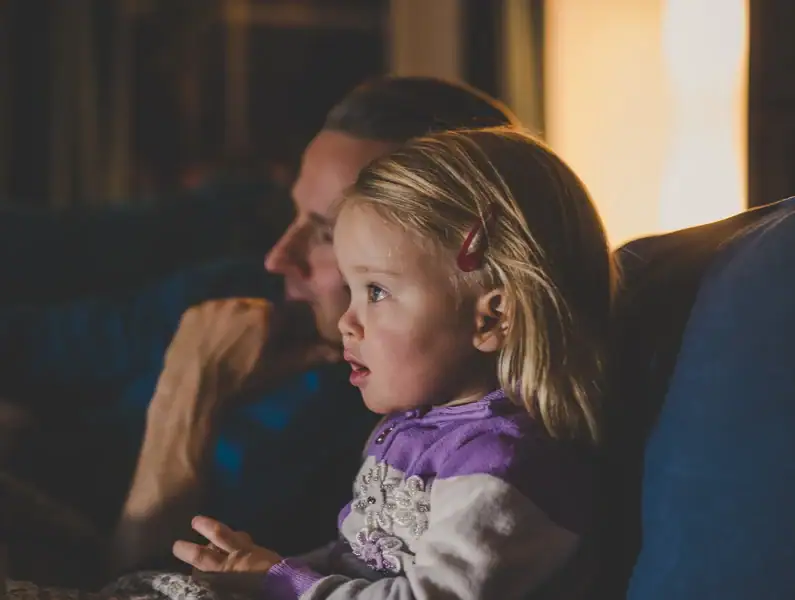 pai e filha surpreendida numa noite de filme. 
