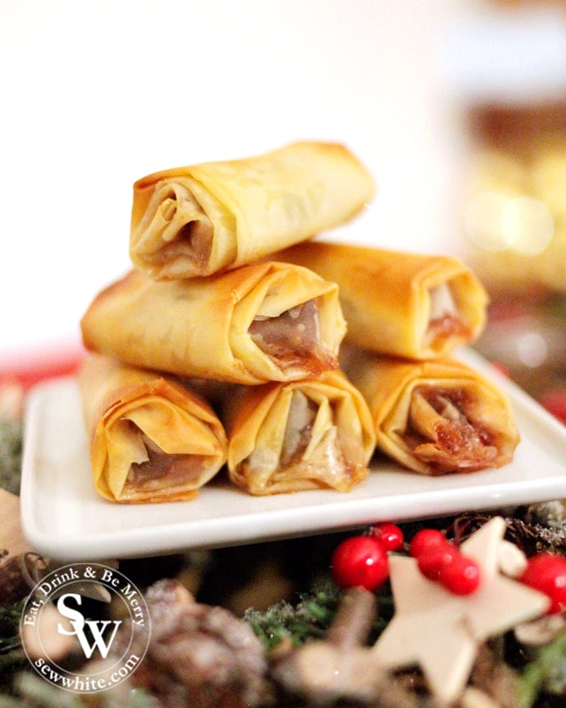 filo pastry mince pie rolls on a white plate.