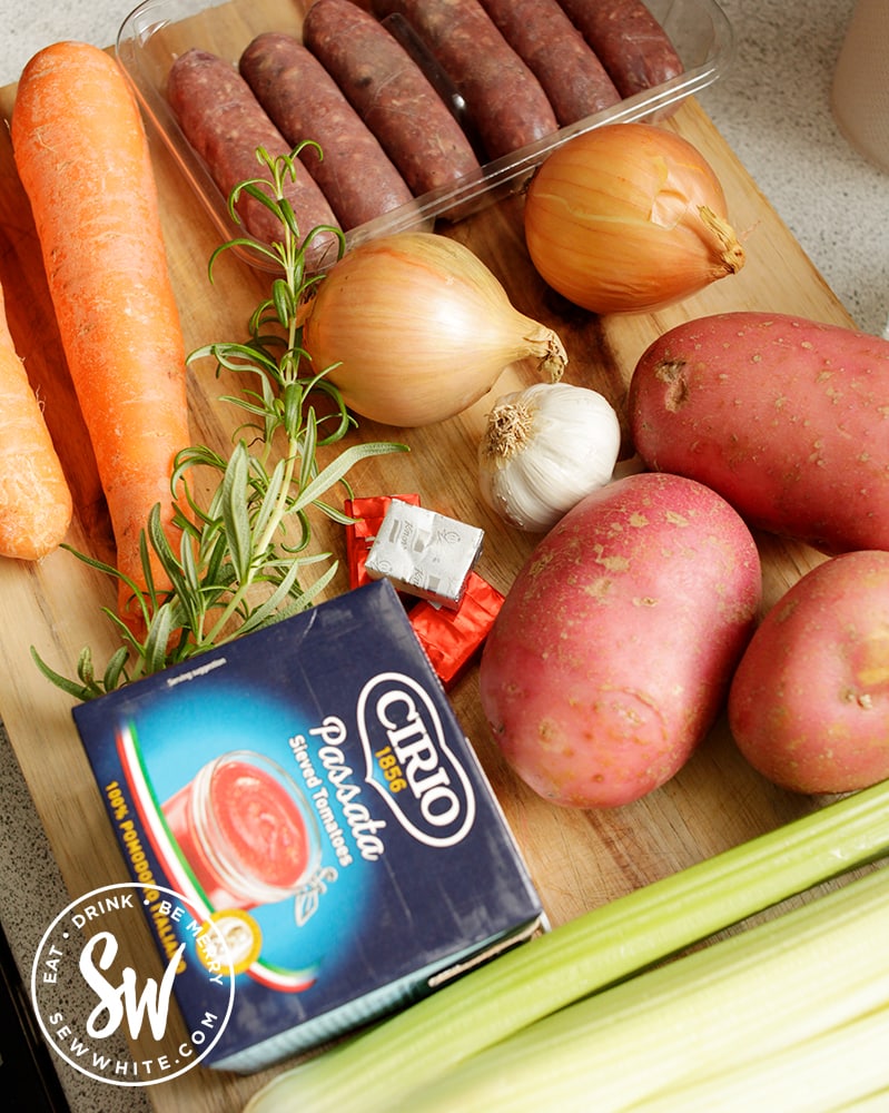 Ingredients ready to make a sausage stew. Potatoes, carrots, celery, garlic, passata and fresh rosemary