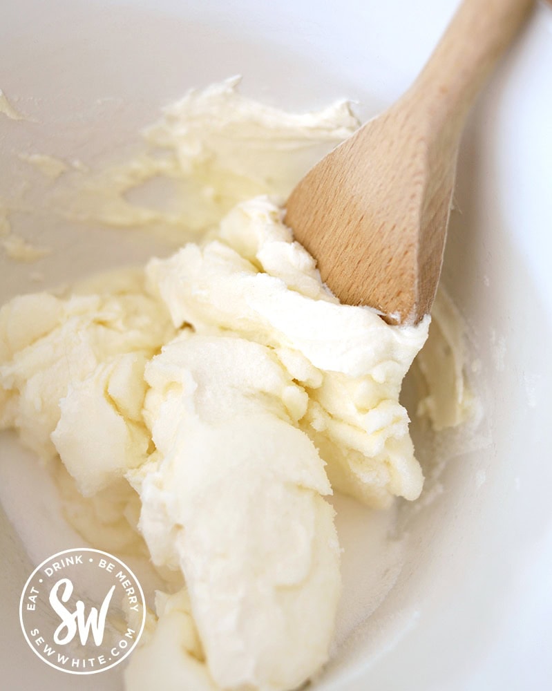 cream cheese and caster sugar being mixed together