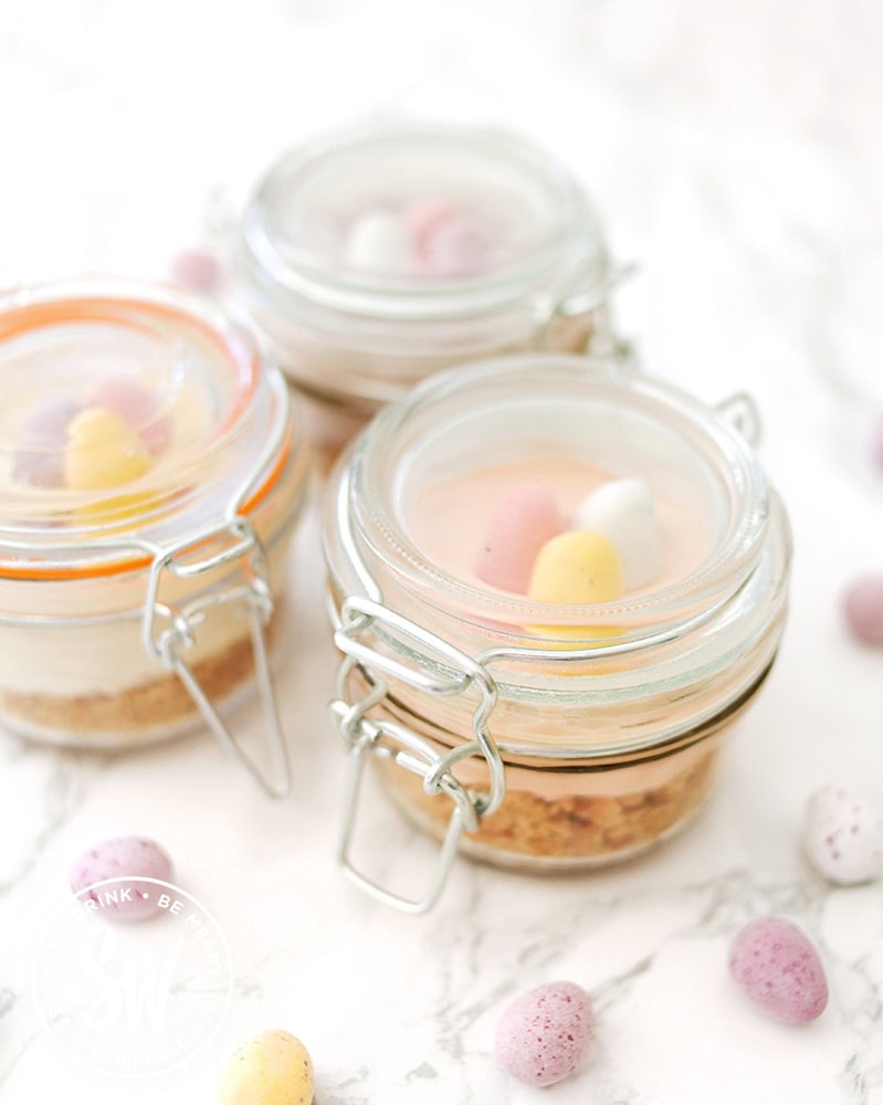 individual mini egg cheesecakes in kilner jars surrounded by mini eggs