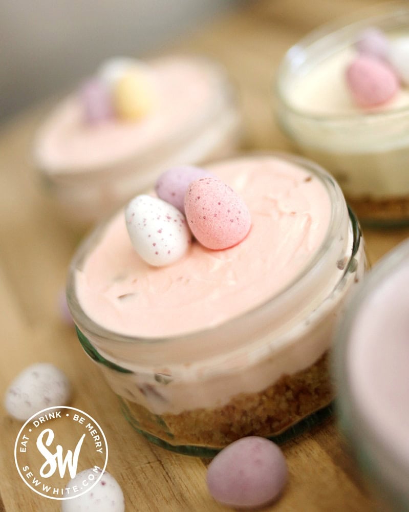 pastel pink mini cheesecakes with mini eggs on tops. 