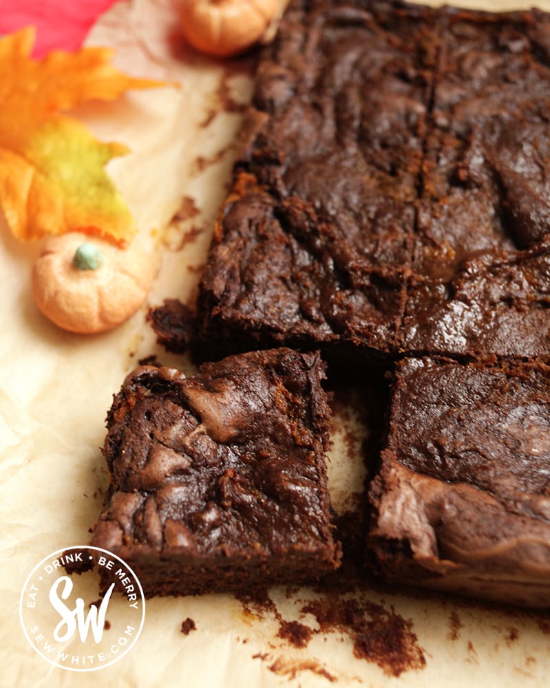 glossy dark chocolate pumpkin brownies on a sheet of parchment paper