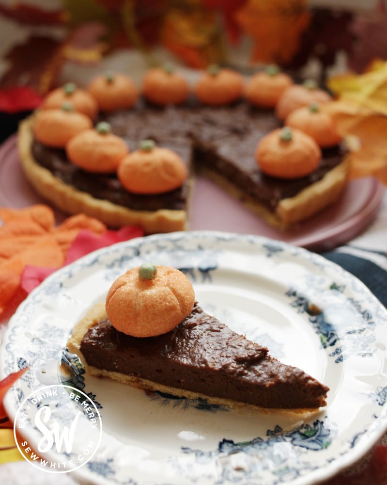 a slice of chocolate pumpkin pie with the pie in the background