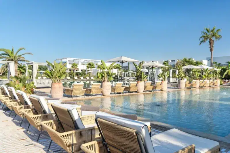 The hotel pool is surrounded by lounge chairs, inviting guests to relax in a serene atmosphere. Evisa Morocco.