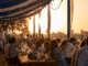 Oktoberfest DUbai 2026 - feiernde Menschen sitzen im Sonneniuntergang in einem Biergarten in Dubai