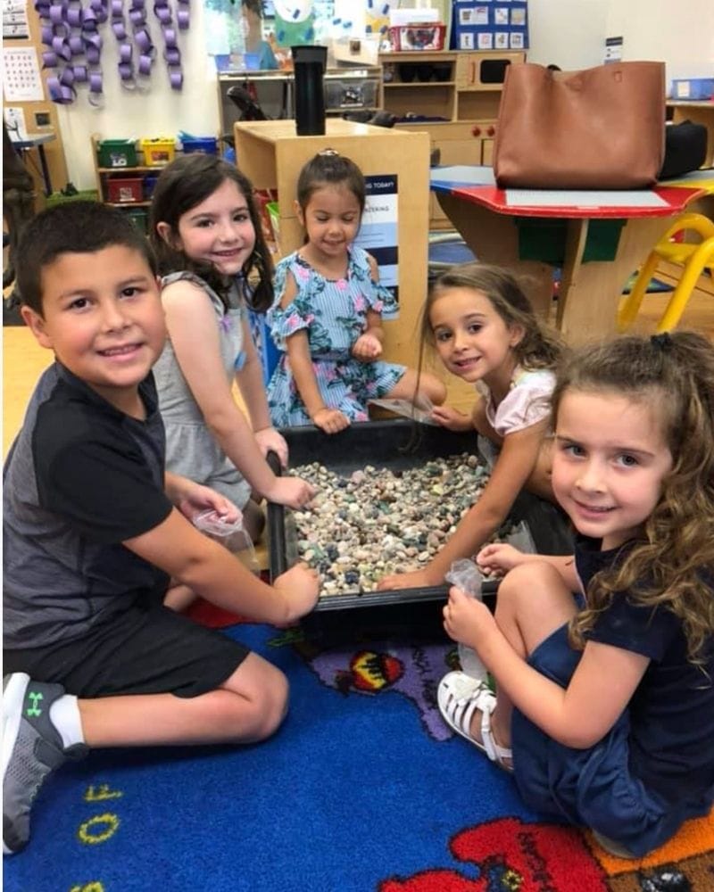 5 young kids digging for fossils and minerals at a school event