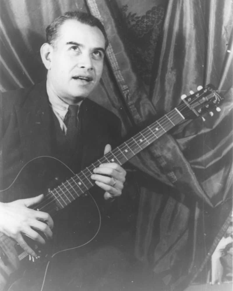 black and white photo of Rufino Tamayo, mexican painter, playing the guitar