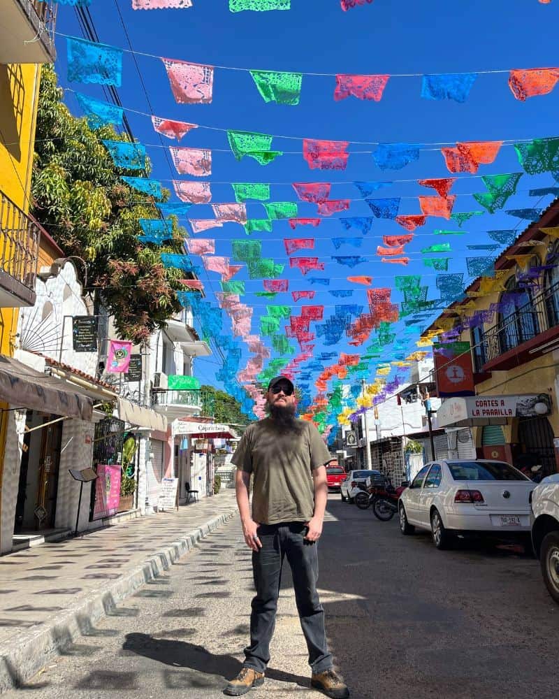 man standing on a colorful street in La Crucecita Huatulco Mexico