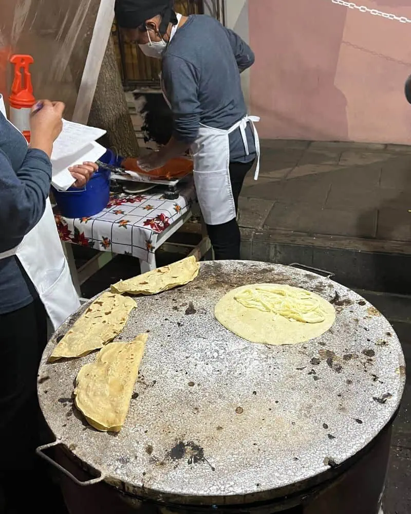 quesadillas cooking on a comal in oaxaca