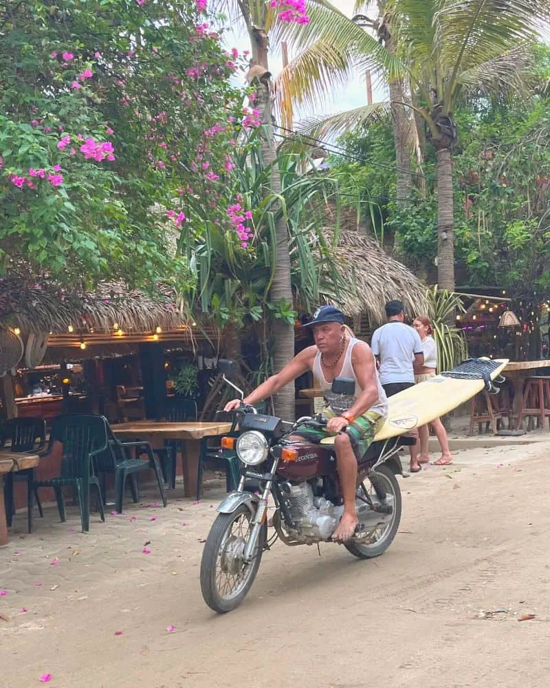 man on motorcycle with surfboard in La Punta Puerto Escondido