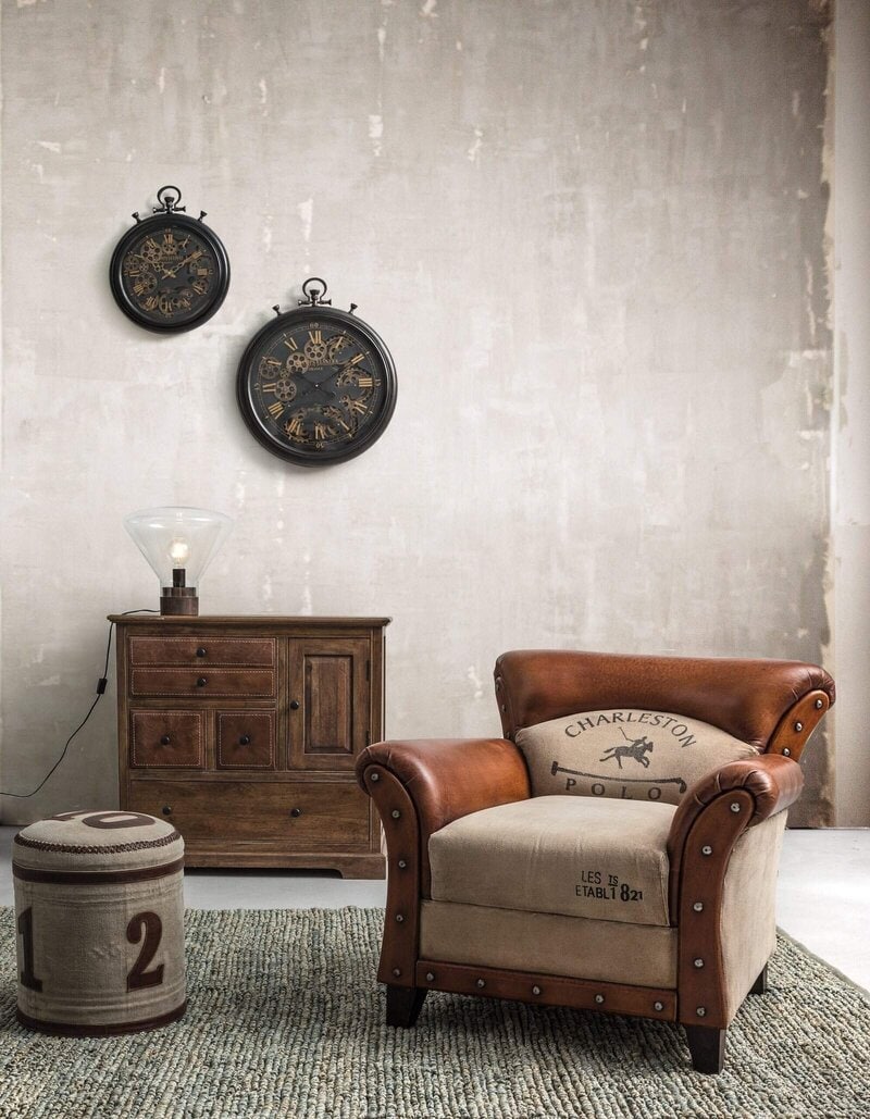Alt text: Orologi vintage neri con ingranaggi visibili su parete neutra.