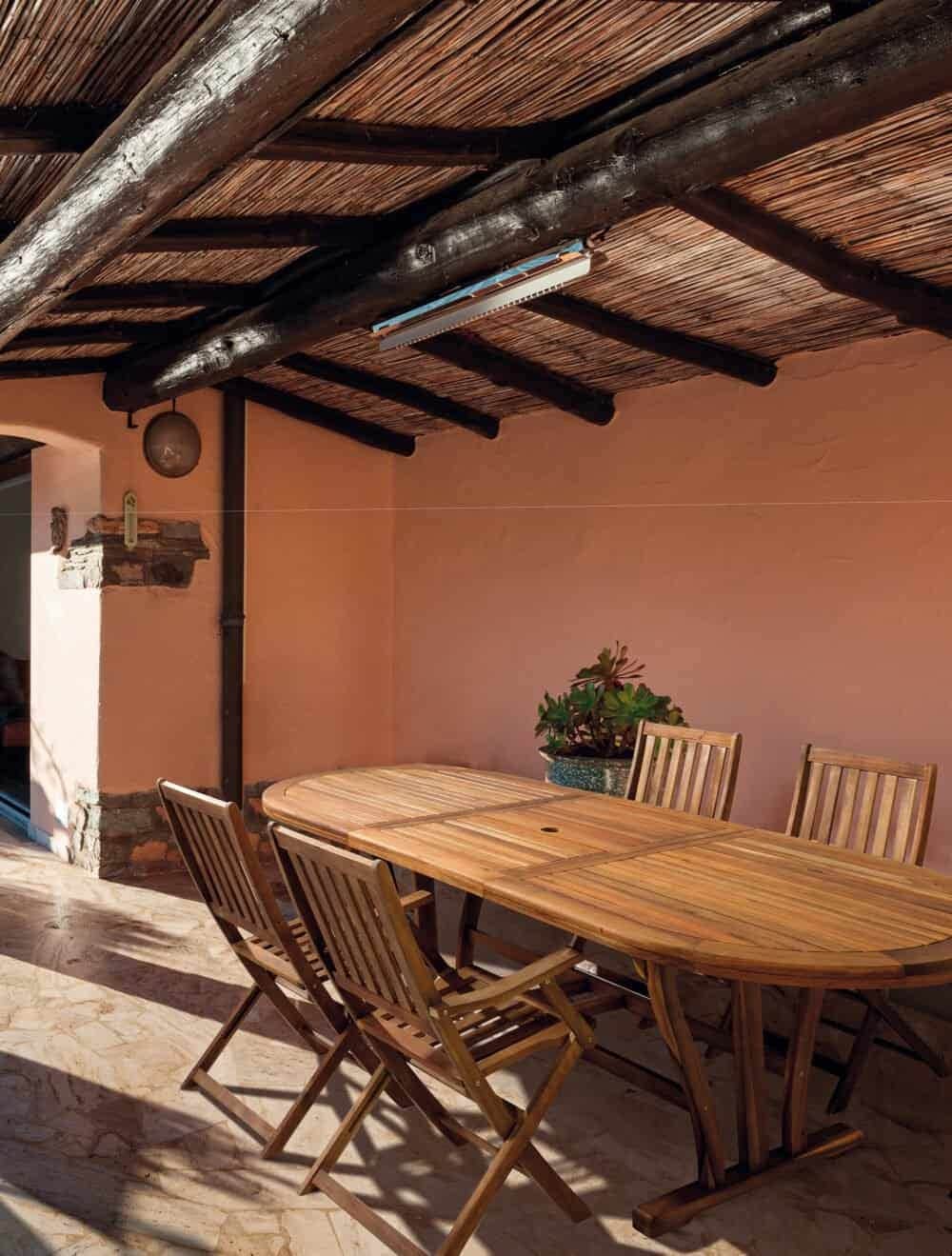 Tavolo esterno in legno in patio all'aperto, perfetto per cene conviviali e momenti di relax.