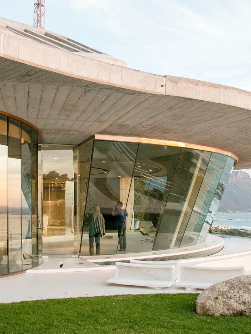 Modern architectural building featuring curved glass walls and concrete elements, designed by Bittoni Architects.