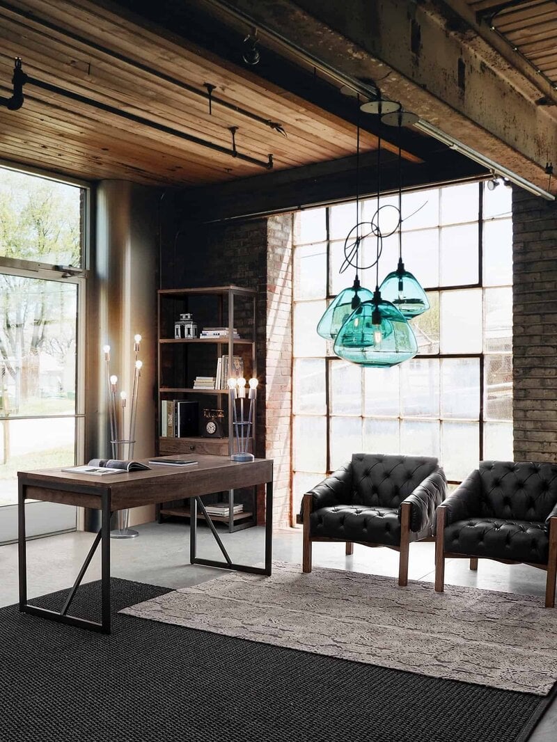 Ambiente moderno in stile industriale con mobili in legno e grandi finestre.