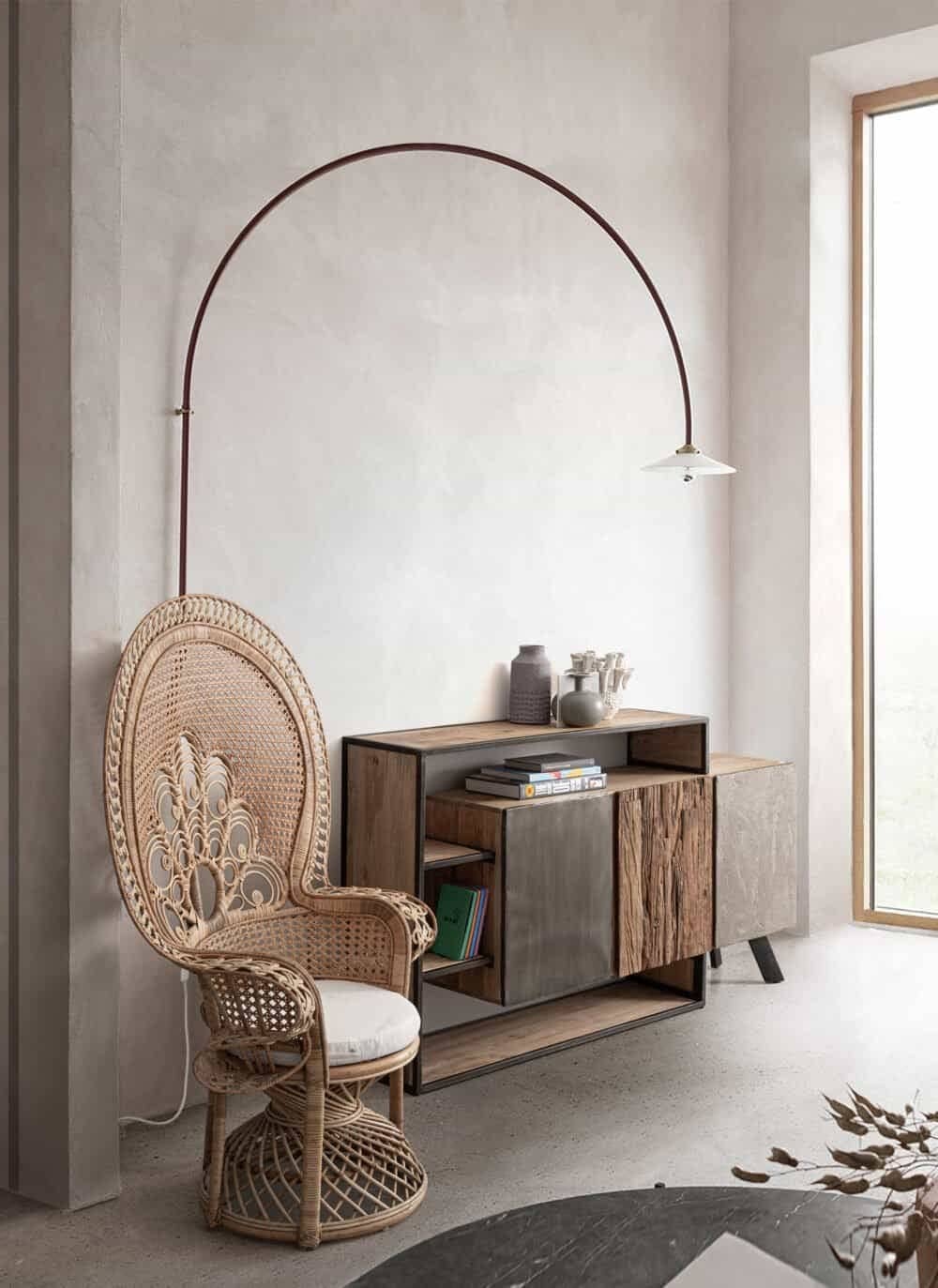 Seduta in rattan con mobili in legno, ambiente luminoso e accogliente per arredo interni in stile naturale.