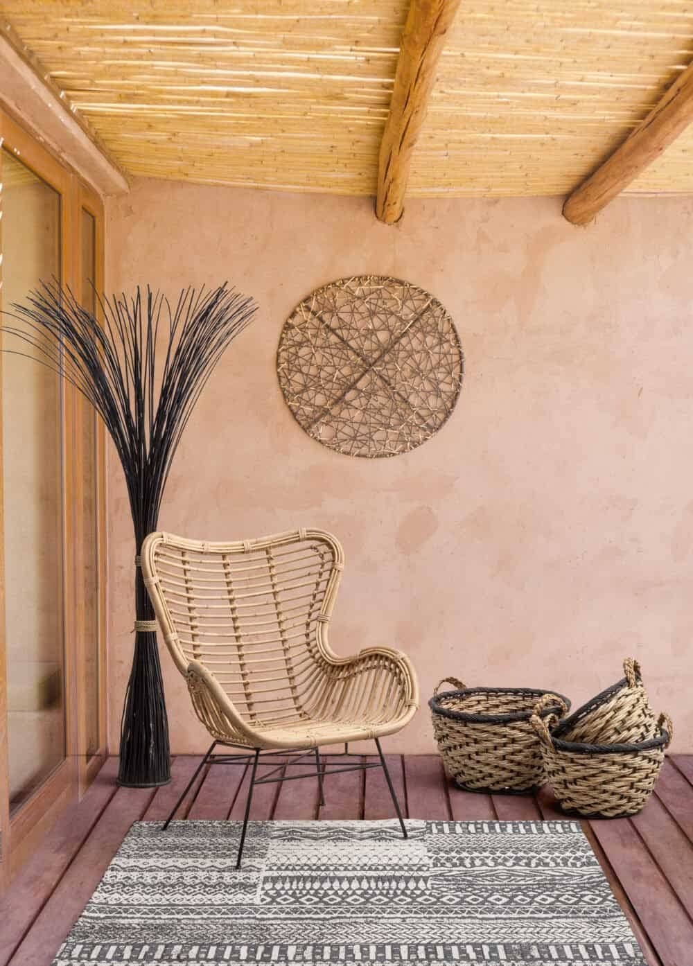 Decorazione boho con poltrona in rattan e cesti in vimini per ambienti da esterno eleganti.