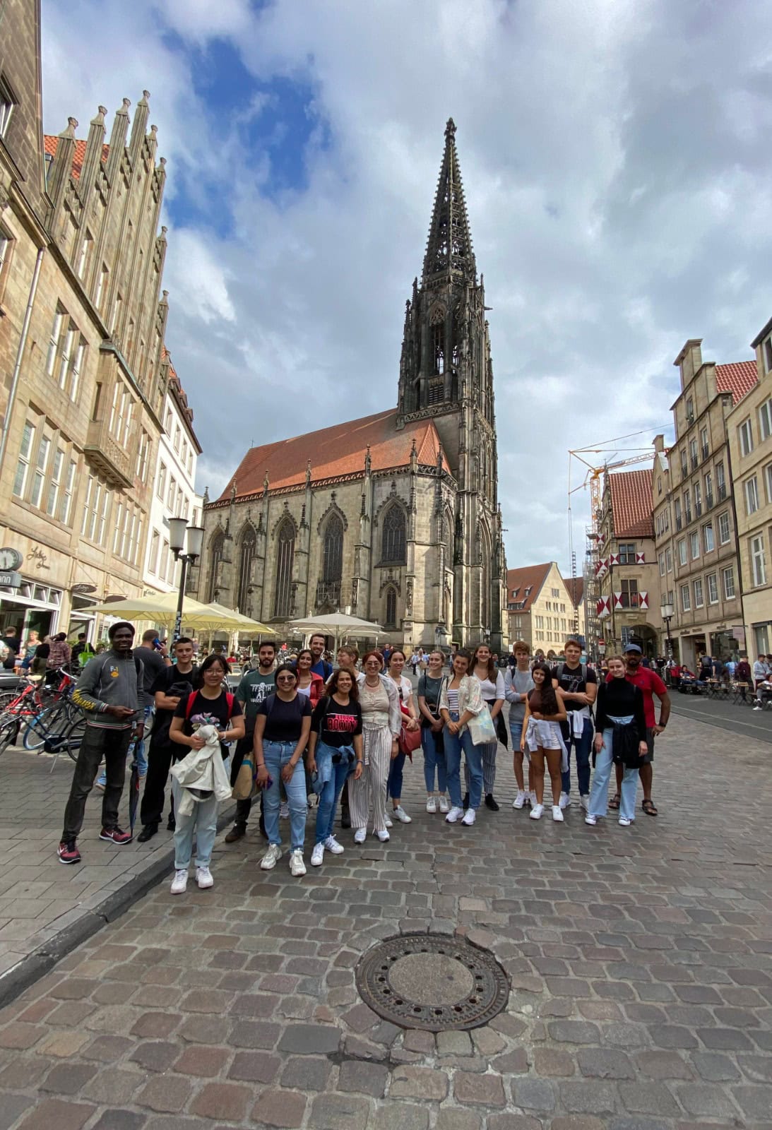 Gruppe junger Menschen vor der Lambertikirche in der historischen Altstadt von Münster