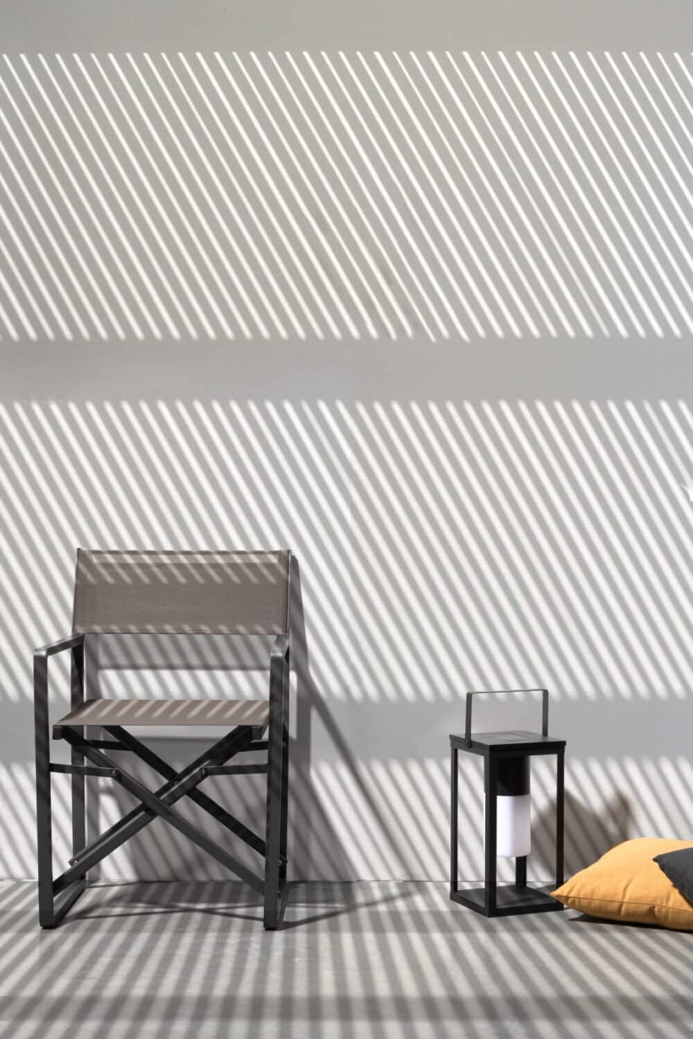 Sedia da regista con ombra di luce sulle pareti in uno spazio moderno e minimalista.