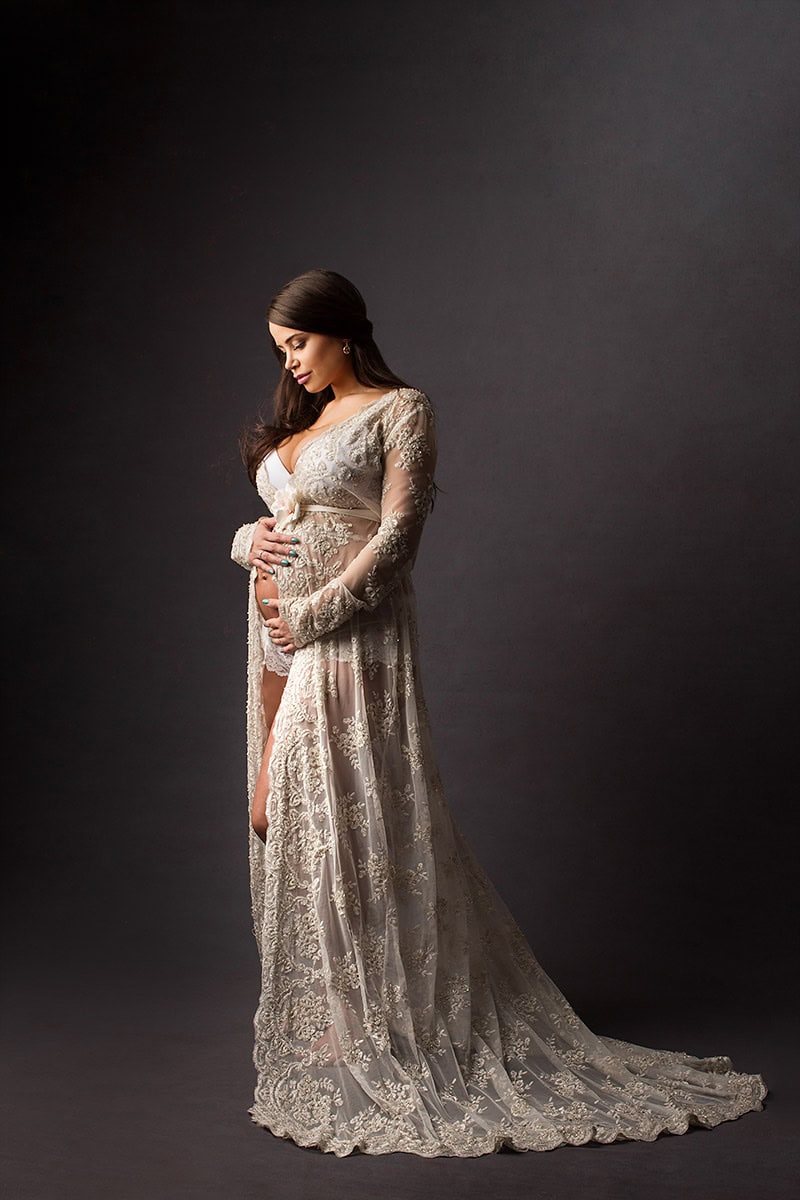 Elegant gravidfotografi av gravid kvinne i lang, blondeskjorte med blonder og broderier, som fremhever den gravide magien, perfekt for gravidbilder og gravidfoto i Norge.