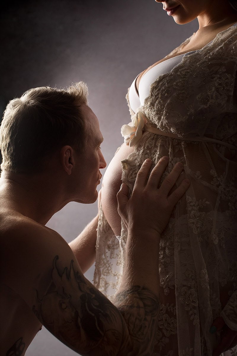 Kjærlighetsfull gravidfotografering av et par som fokuserer på den gravide kvinnens mage med intime og kunstneriske uttrykk. Perfekt for gravidfoto og mammaromantikk i Norge.