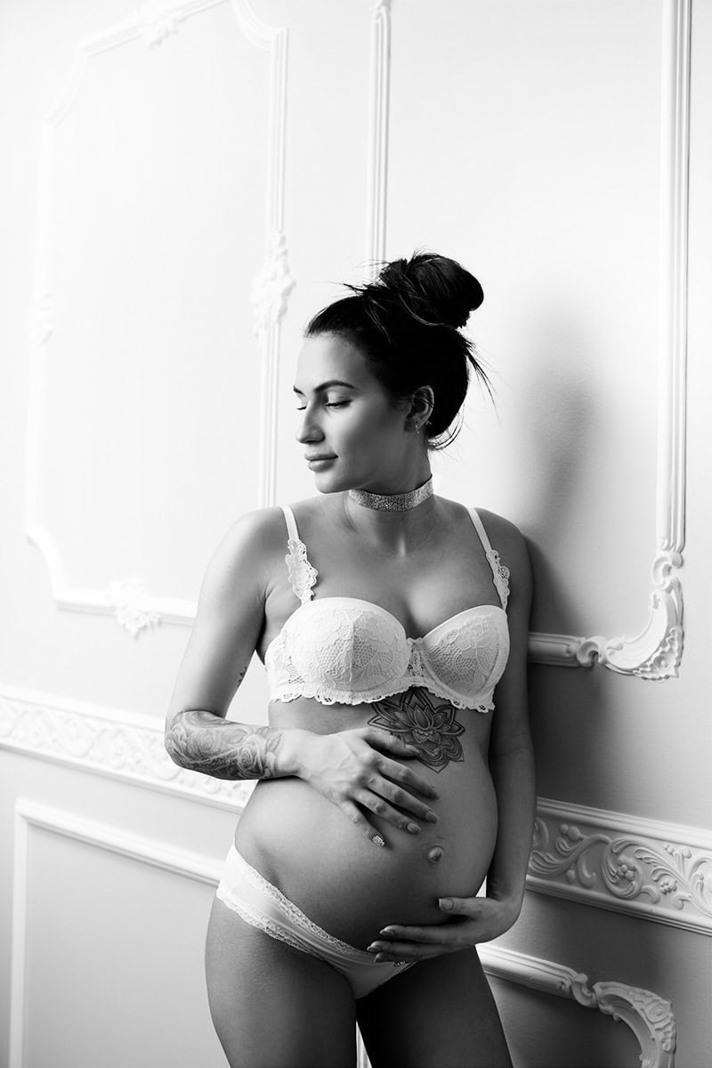 Elegant gravidfoto av gravid kvinne i lingerie, frosselig i svart-hvitt, fremhever den vakre og naturlige graviditetsreisen, ideell for gravidefotografering.