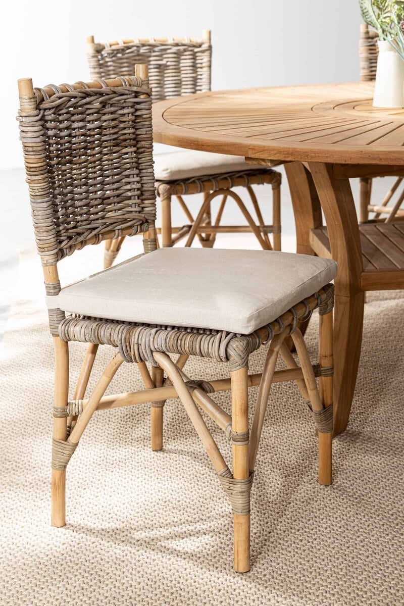 Sedia in rattan con cuscino beige, ideale per arredamento outdoor e indoor, eco-friendly, con design ergonomico.