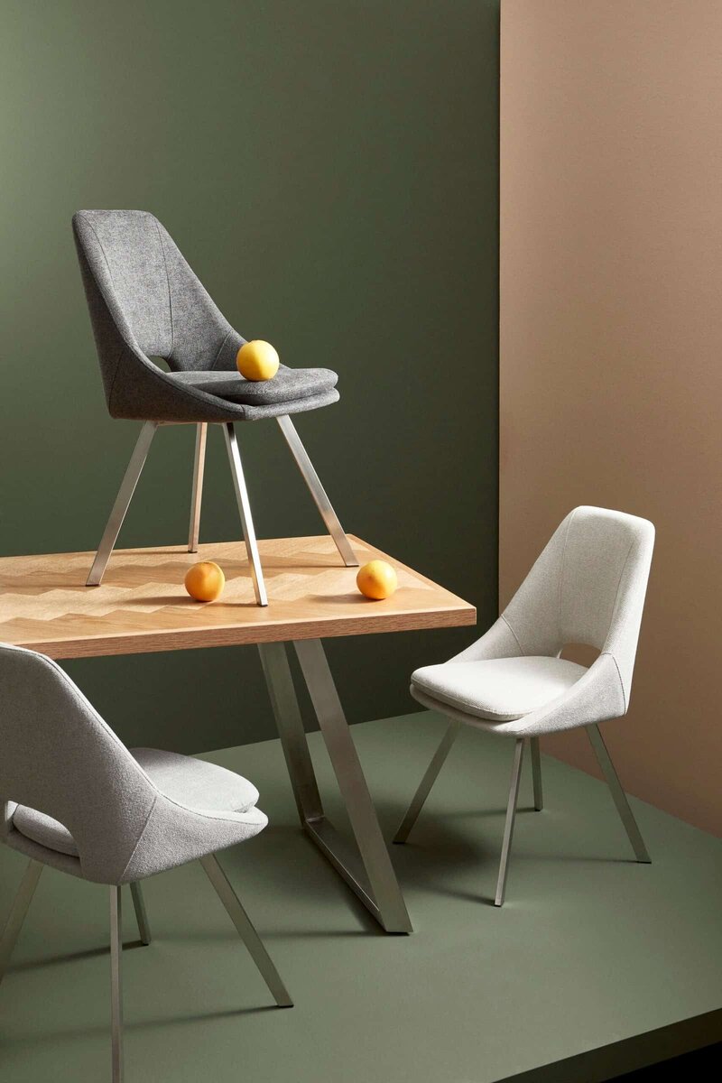 Sedia moderna in tessuto grigio con design innovativo, ideale per soggiorno e zona pranzo.