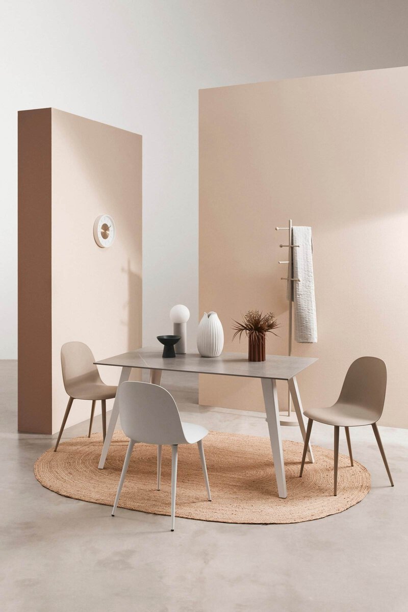 Sedia moderna, tavolo elegante e decorazioni di design in ambiente luminoso e raffinato.