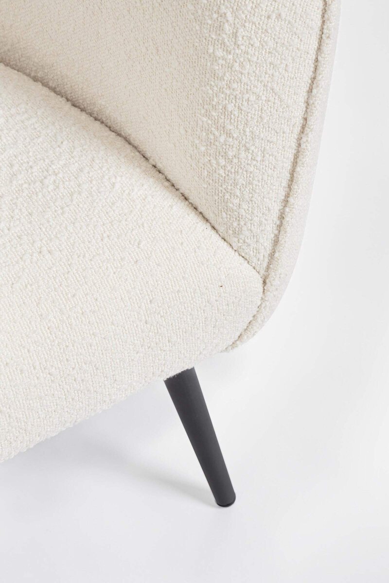 Divano in tessuto beige con piede nero, design moderno, perfetto per ambienti chic.