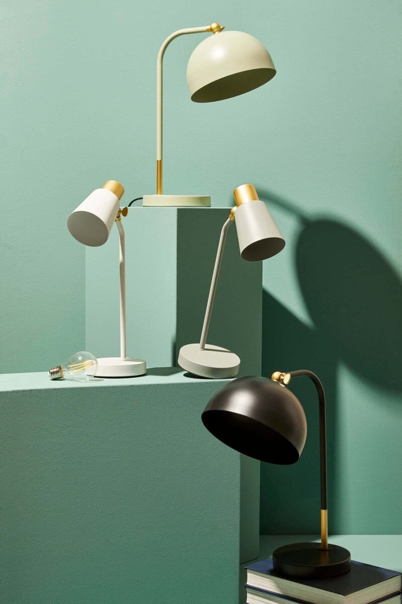 Lampada da tavolo elegante con finiture in oro e nero, perfetta per decorazioni di stile contemporaneo.
