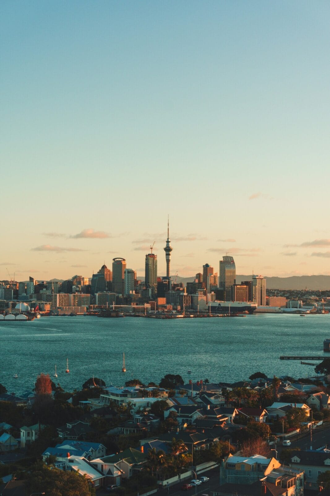Auckland Skyline bei Sonnenuntergang mit Blick auf den Sky Tower und den Hafen.