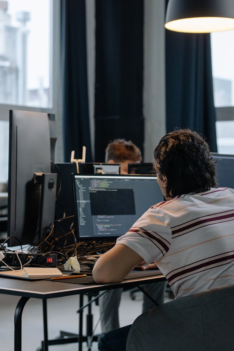 Team of developers working together on computers in a modern tech office.