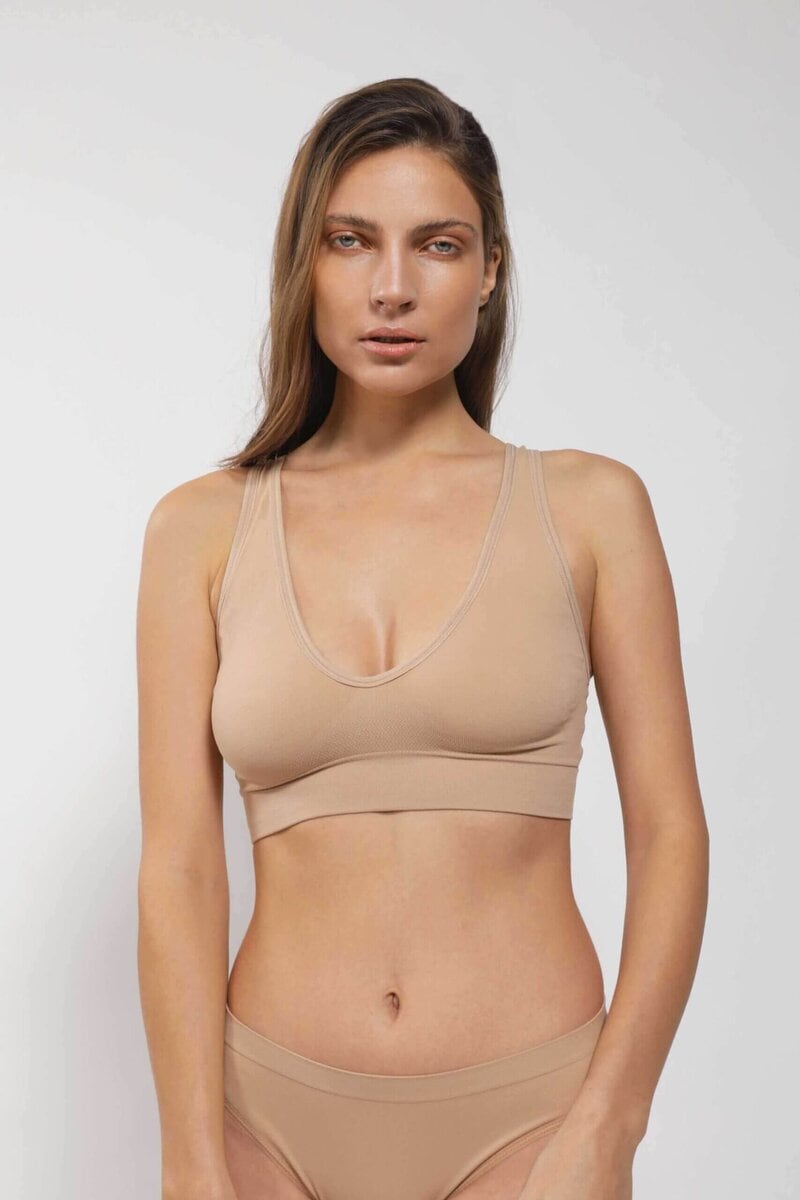mujer de frente luce brasier escotado con copas tiras gruesas y calzon color beige