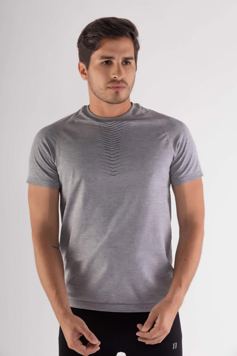 hombre de frente con las manos hacia abajo luce camiseta color gris y short color negro