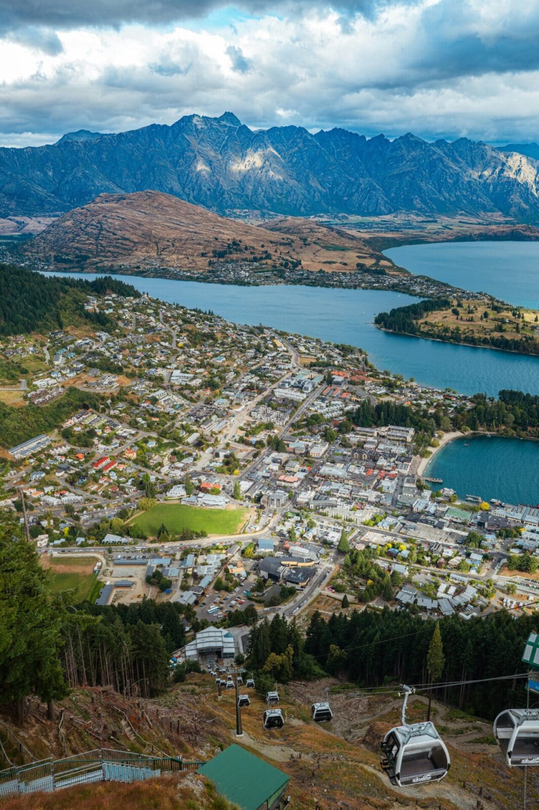 Panoramablick auf Queenstown, Neuseeland, mit der Skyline Gondola, dem Lake Wakatipu und den majestätischen Remarkables-Bergen im Hintergrund.