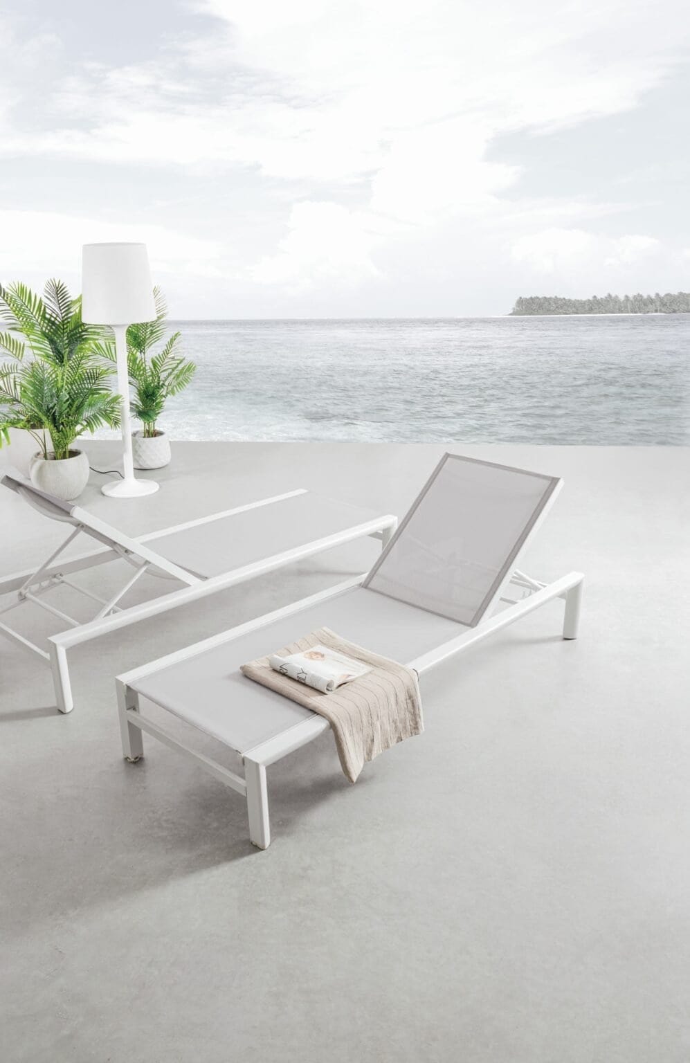 Sdraio bianche e piscina con vista sull'oceano, atmosfera di stile e comfort.