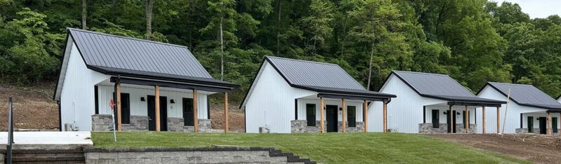 Row of white on-site wedding cottages with metal roofs at Romaine Valley Weddings & Events in Fenton, Missouri