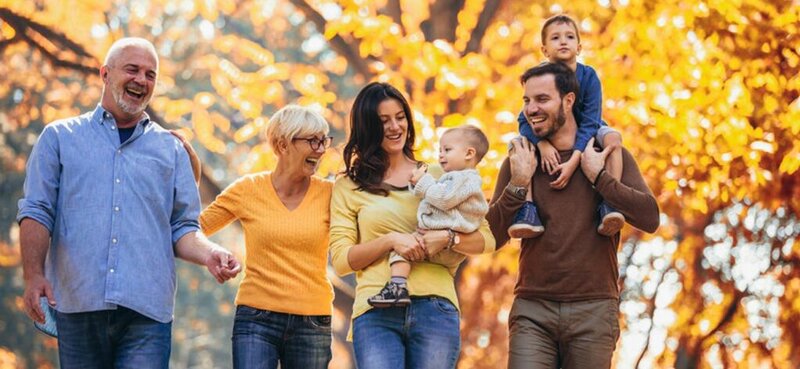 Multi-generational family walking through the woods.