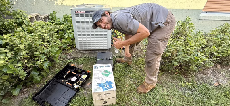 Air Conditioning Repair Service - Man Working on an AC Unit