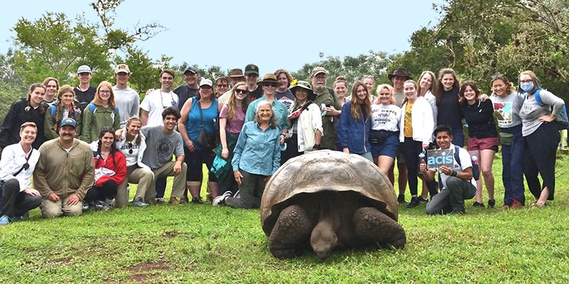 Student group in Ecuador behind a giant tortoise